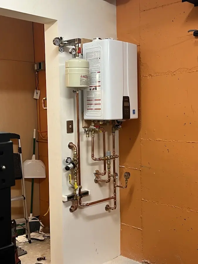 Plumbing technician inspecting water heater connections in Maryville